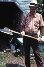 Wood carver Charlie Lewis holding an axe - Perry, Florida.