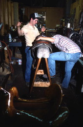 Unidentified man helping David Cauley repair a saddle horn - Lakeland, Florida