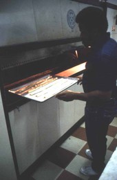 Jimmy Walton placing guava pastries into the oven - Jacksonville, Florida.