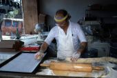 Marty Kaufmann breaking off pieces of dough into knishes at Suzanne's Foods - Miami, Florida.
