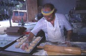 Marty Kaufmann breaking off pieces of dough into knishes at Suzanne's Foods - Miami, Florida.