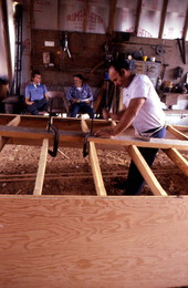 Bobby Shiver building an oyster skiff while two men watch - Eastpoint, Florida