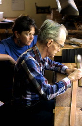 Leather worker Bob Dellis works while apprentice Kitt Maynard looks on - Okeechobee, Florida