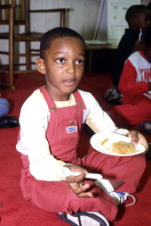 John E. Ford Elementary School kindergarten student sampling Filipino Pancit prepared by Erma Celzo - Jacksonville, Florida