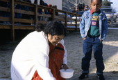Kindergarten student watching Prema Kumar give a rice flour painting demonstration - Jacksonville, Florida.