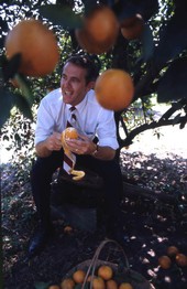 Portrait of Lieutenant Governor Ray Osborne peeling an orange