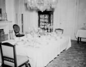 Dining room table with tableware and silverware sets on display at Goodwood