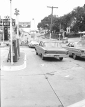 Automobiles in parking area of service station.