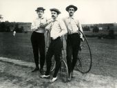 Three young men with Penny-Farthing bicycles.