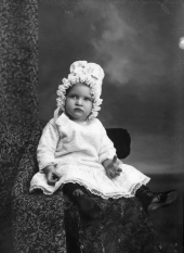 Infant wearing a bonnet.