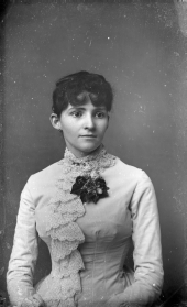 Young woman fashioned in bodice trimmed with lace.