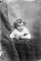 Child leaning on the arm of a chair.