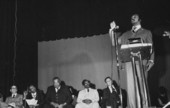 Men watching Civil rights leader Jesse Jackson delivering a speech in an auditorium - Tallahassee, Florida.