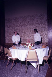 Employees standing by a dining table inside the Hilton Hotel - Tallahassee, Florida.
