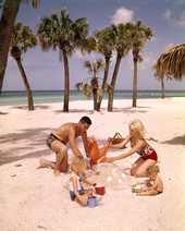 Family building a sandcastle at the beach in Sarasota, Florida.