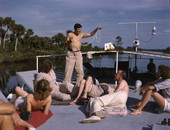 Joe Steinmetz performing a magic trick aboard the shantyboat "Lazy Bones".