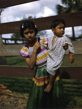 Portrait of Seminole girl holding her baby brother at the Brighton Indian Reservation.