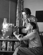 Philip Wylie with his wife listening to the radio for weather reports in Miami, Florida.