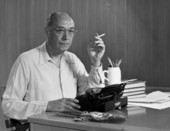 Portrait of author Eric Hodgins sitting by his typewriter.