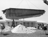 Gold Key Pools of Venice employees using a crane to install a fiberglass pool in the backyard.