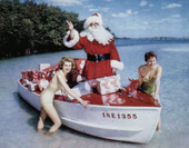 Santa Claus with presents in a boat being assisted by two young ladies in Sarasota, Florida.