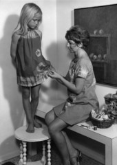 Mother sewing daughter's tie-dye dress in Sarasota, Florida.