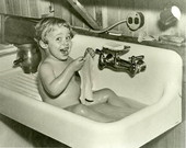 Photographer's daughter Lois Duncan having a bath in the sink.