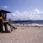 View showing people at the beach near the lifeguard station and pier in Lake Worth, Florida.
