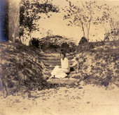 Unidentified woman sitting on the steps leading to the sunken gardens on Koreshan Unity property in Estero, Florida.