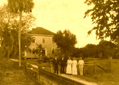 Koreshans standing by the gate in front of the Koreshan Unity's Guiding Star Publishing House in Estero, Florida.