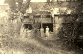 Koreshan Theodore Naeselius posing with a woman in front of the old log house in Estero, Florida.