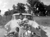 Young widow Hattie Mae Haynes standing with her daughters in front of an oldsmobile - Hamburg, Florida