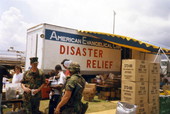 View showing military personnel and aid next to disaster relief truck following Hurricane Andrew in Dade County, Florida.