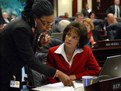 Representatives Audrey Gibson, D-Jacksonville, left, and Denise Grimsley, R-Sebring, conferring on the House floor during the legislative session in Tallahassee, Florida.