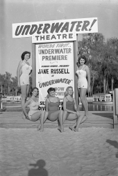 Women in Jantzen suits posing by sign for underwater theater at Silver Springs.