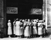 Women wainting for Bernard's dress shop doors to open on sale day