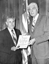 Andre Bialolenki holding proclamation with Miami Beach mayor.