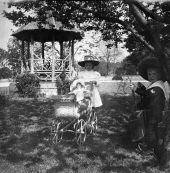 Girl and her doll carriage near gazebo