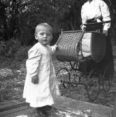 Child beside baby carriage