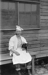 Cook with piglet - Camp Joseph E. Johnston