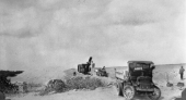 Speeder shovel and trucks handling rock for surfacing