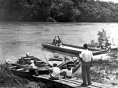 Workers fastening a motor onto barge for bees