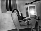 Mildred Kyle Hollister, wife of Rick Hollister, in chair reading book