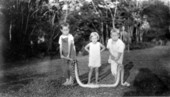 Unidentified children with a dead rattlesnake