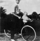 Unidentified man and child on a bicycle