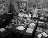 View of Florida News Bureau employees in an office looking at photographs.