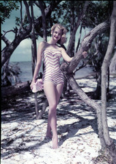 Unidentified young woman modeling by the beach.