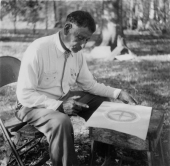 Seminole Indian Josie Billie sitting in a chair looking at a Wheel of Life