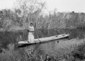 Seminole woman Nellie Tommie and her son in a wooden canoe
