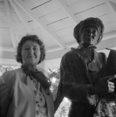 Woman standing by statue